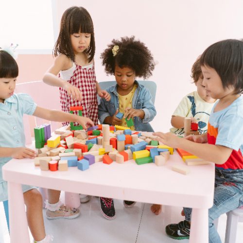 Group of diversity kids playing with colorful blocks on table in class at the kindergarten.Kindergarten international school, education concept.
