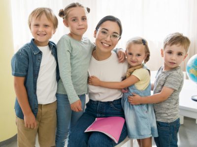 smiley-teacher-holding-her-students