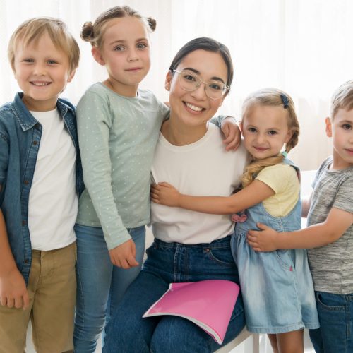 smiley-teacher-holding-her-students